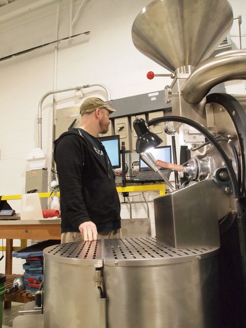Operating a coffee roaster at the Eco-Coffee roastery and warehouse.