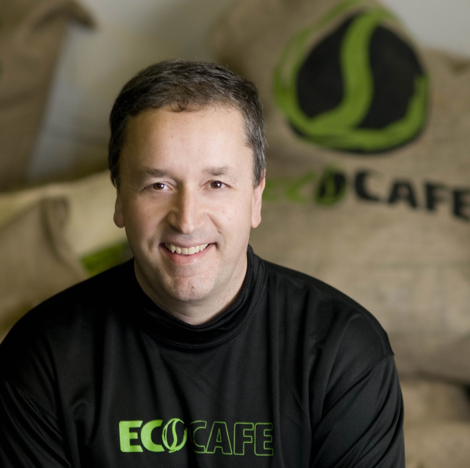 Ed Denyer, founder of Eco Coffee, with a stack of branded cloth coffee bags behind him