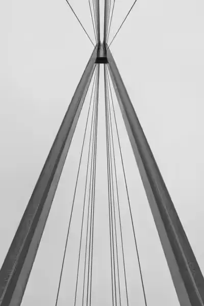 Geometrický detailní záběr na konstrukci mostu v černobílém provedení.