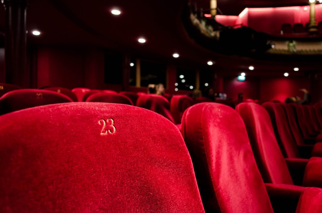 Asientos rojos en una sala de cine. Las APIs y el software de gestión nos puede facilitar muchísimas tareas.