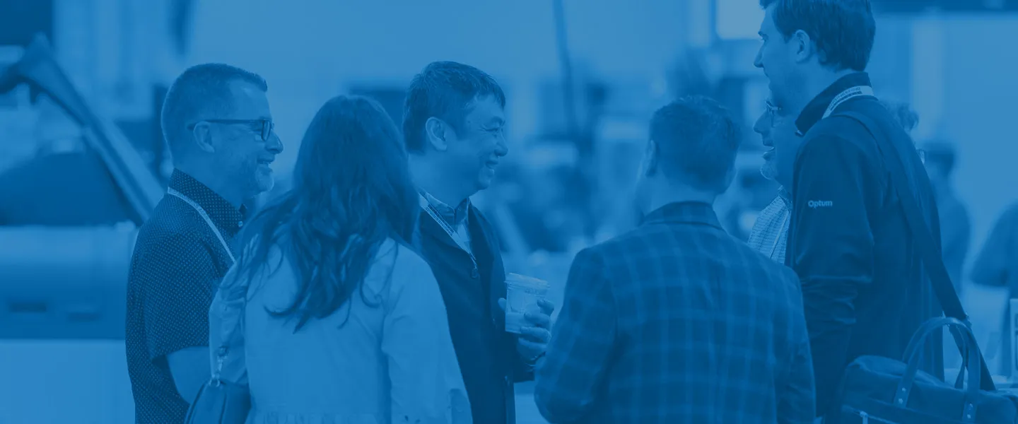 Group of six people engaged in conversation at a networking event.