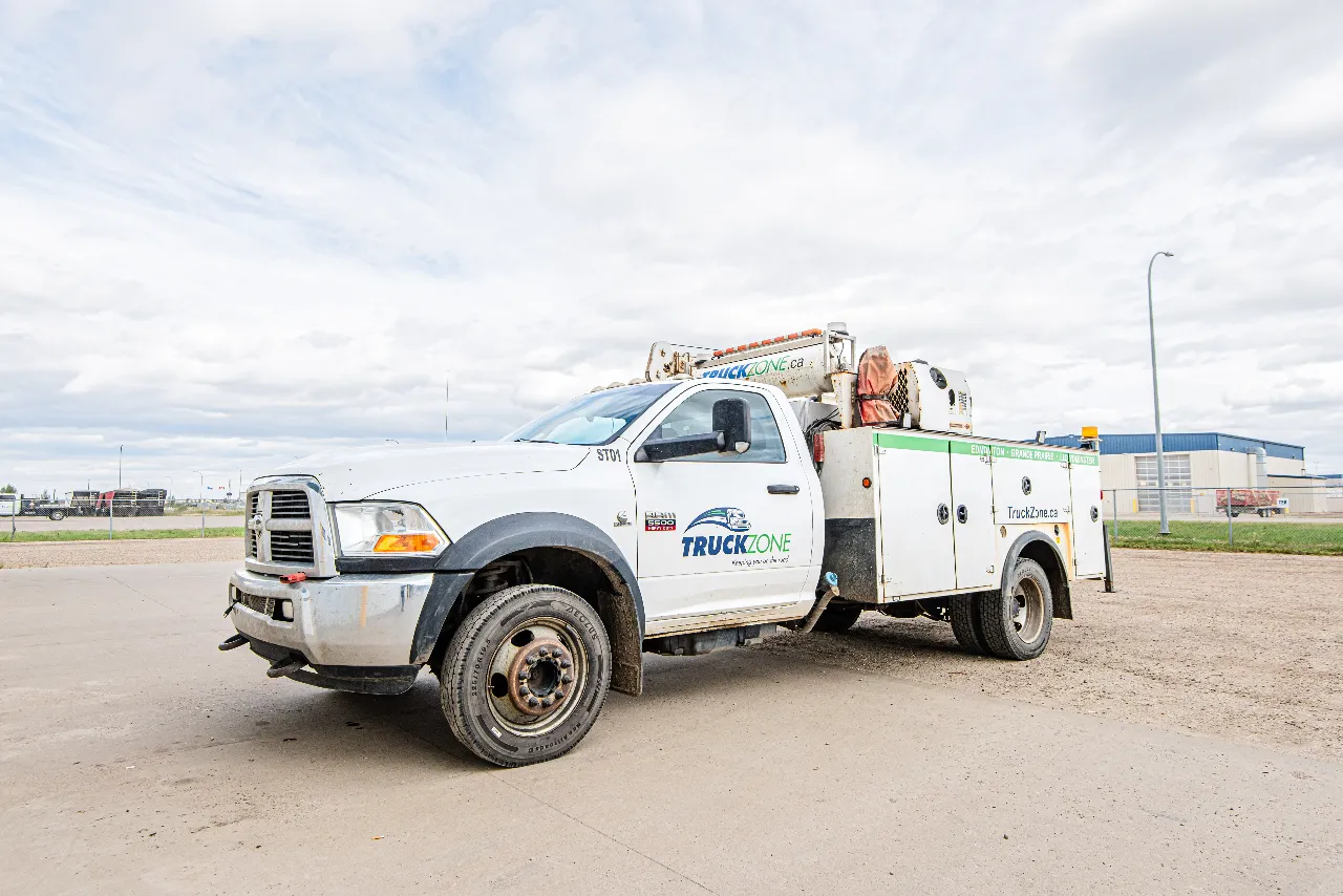 Mobile repair service truck with TruckZone branding and crane body parked at a heavy-duty repair facility.