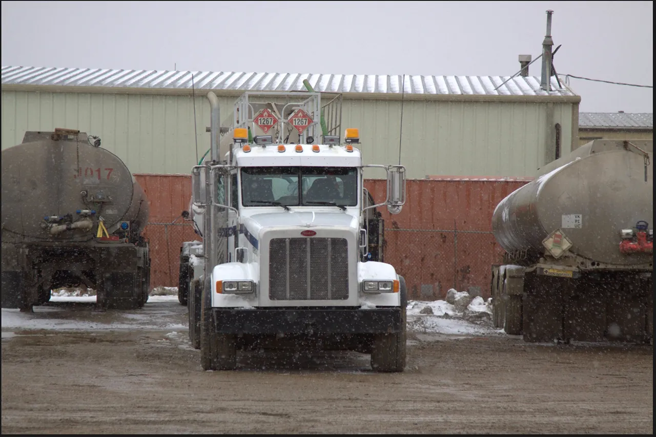 Oilfield trucks parked in a snowy heavy-duty yard, with tanker markings 1267, 1287, and 1017 visible.