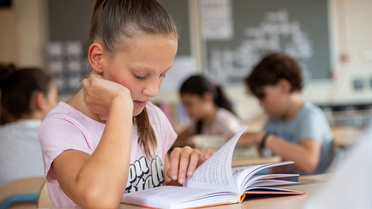 A photo of a young student reading from a textbook
