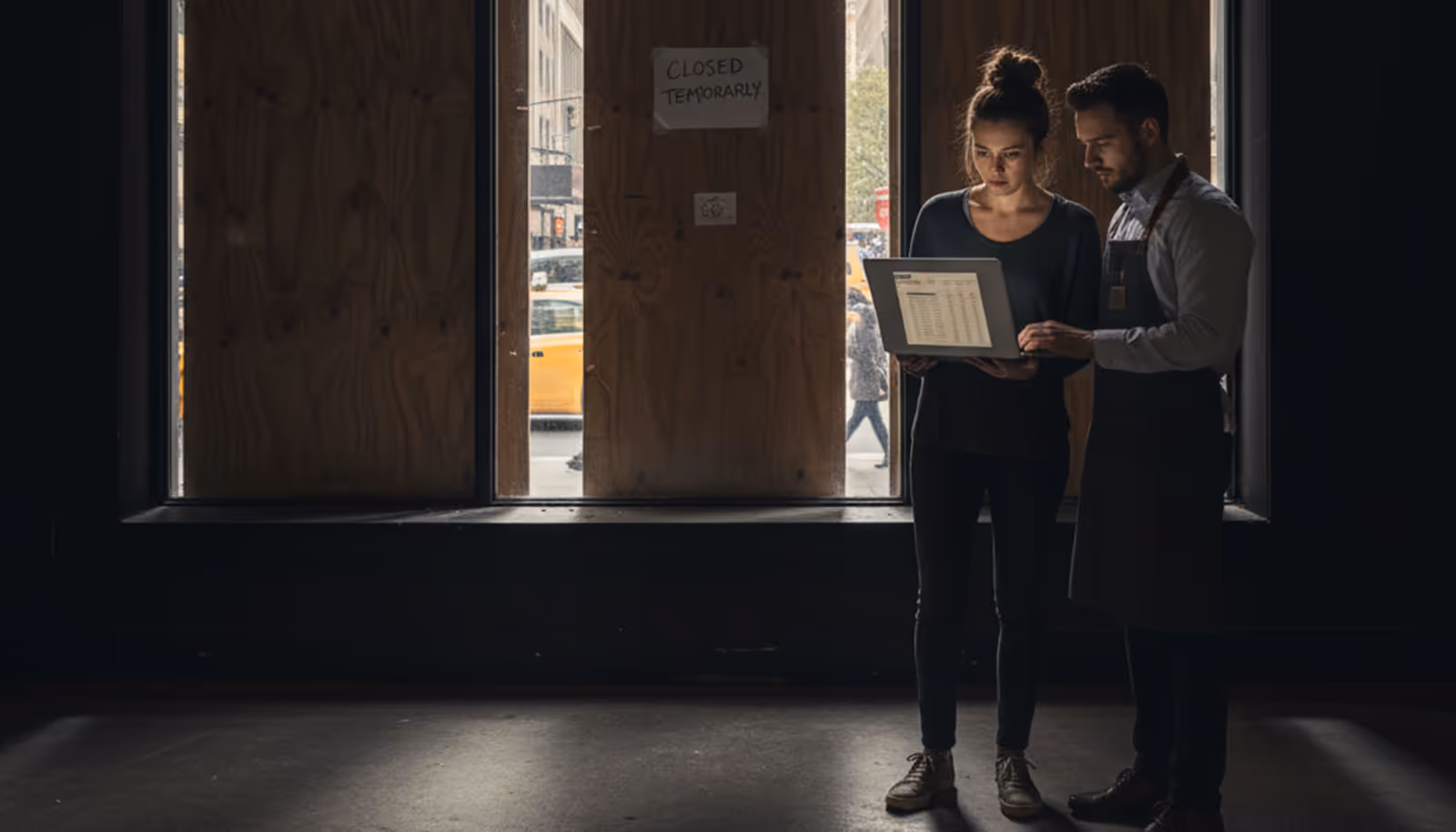 Two business people reviewing documents in a dark office hallway