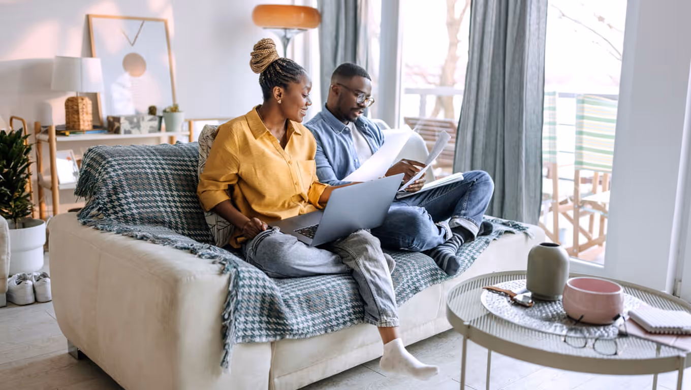 Young smiling couple working from home, going over paperwork