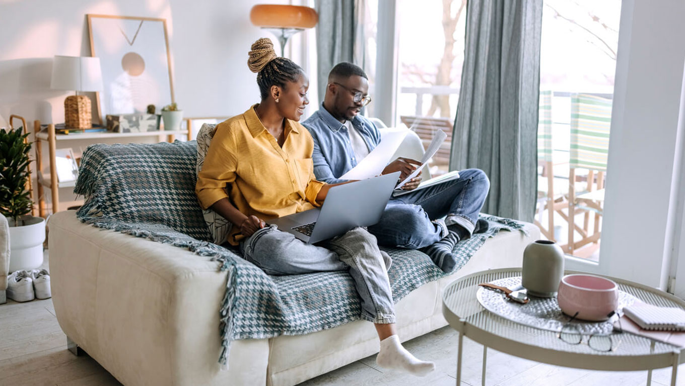 Young smiling couple working from home, going over paperwork