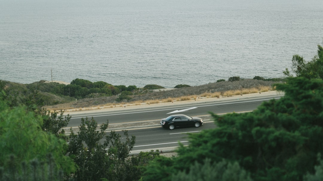 car driving along scenic coastal road - auto insurance quotation
