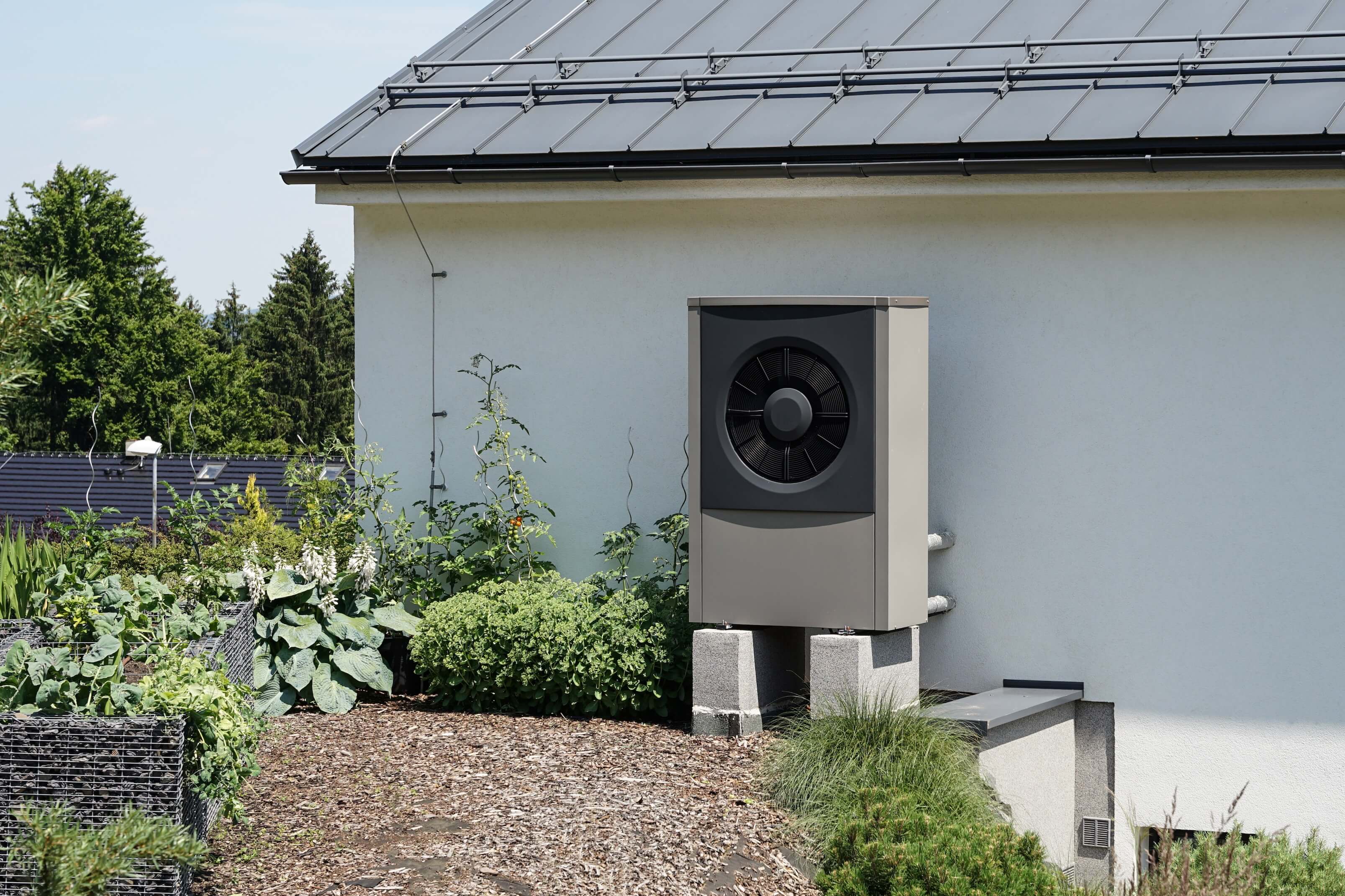 Wärmepumpen-Installation an Haus mit Garten