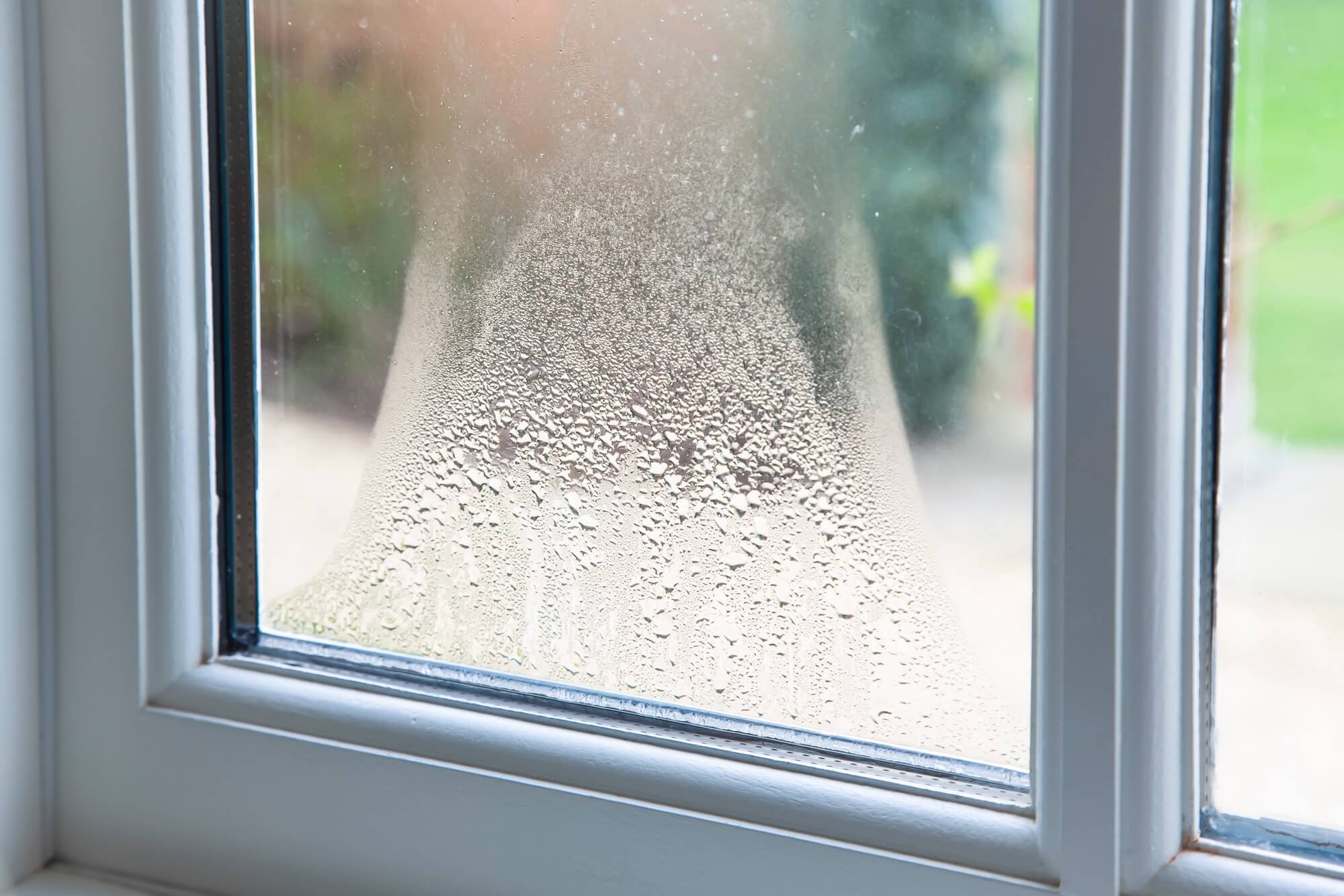 Kondenswasser bildet sich zwischen den Scheiben eines zweifach verglasten Fensters