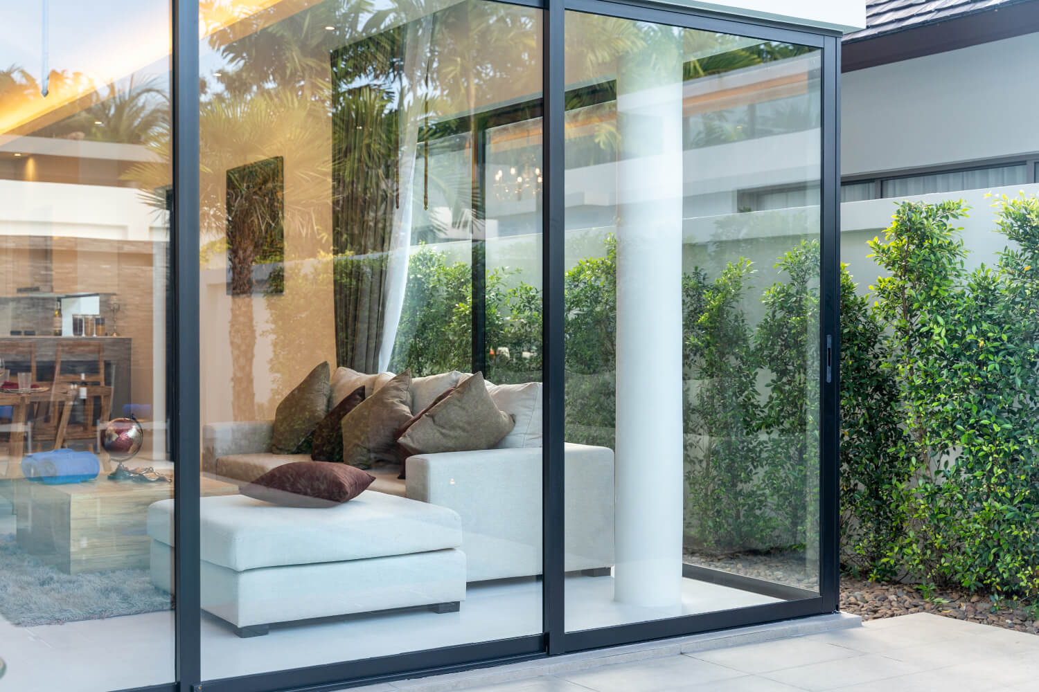 Moderne Terrassentür aus Stahl mit großer Glasfront bietet einen Blick ins Wohnzimmer