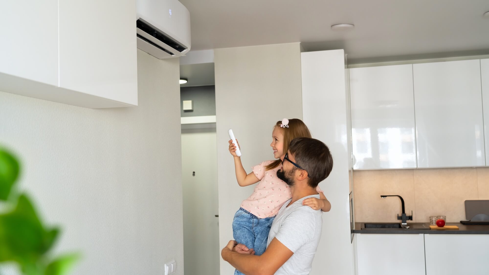 Vater und Tochter bedienen eine Klimaanlage im Haus