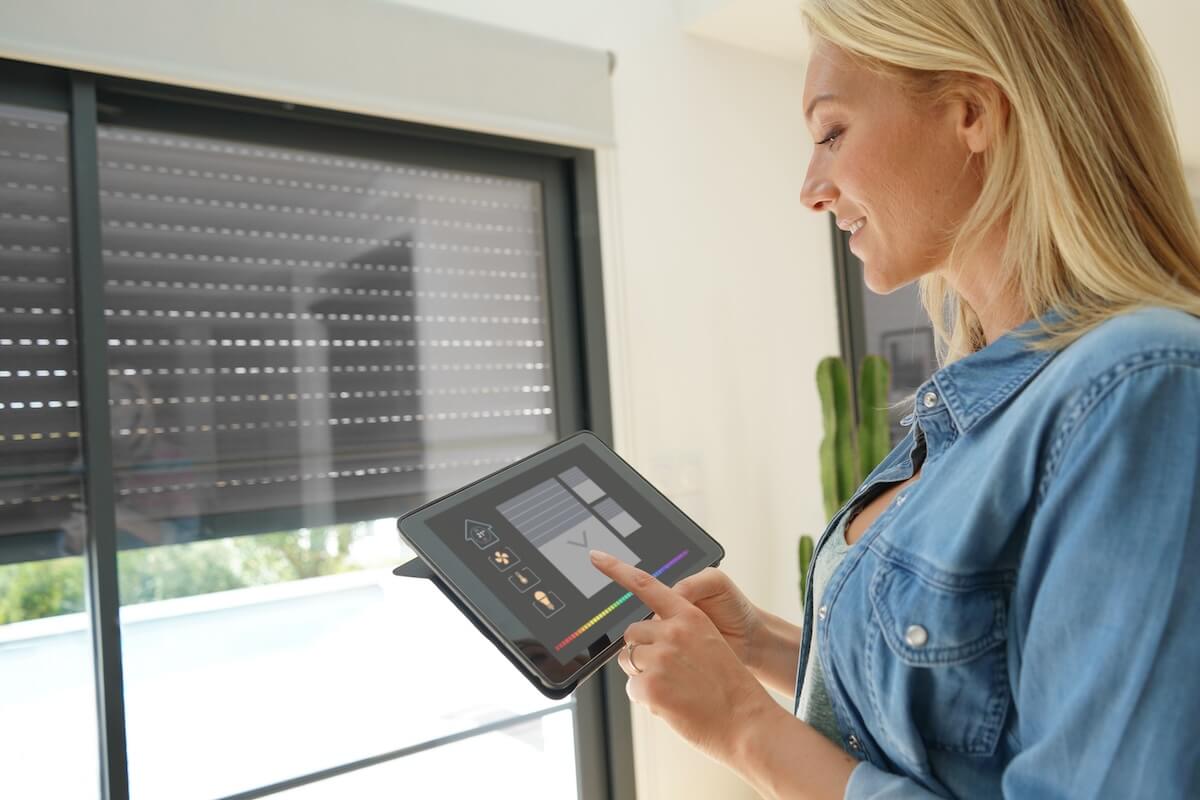 Frau steuert Rollläden über Smart-Home System