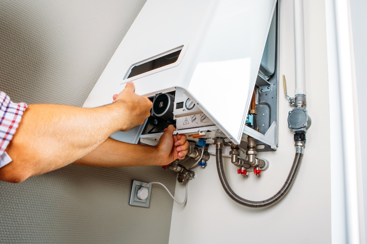 Nahaufnahme einer geöffneten Gasheizung mit Wasser- und Gasanschlüssen – technische Einblicke in förderbare Heizsysteme auf Gasbasis.