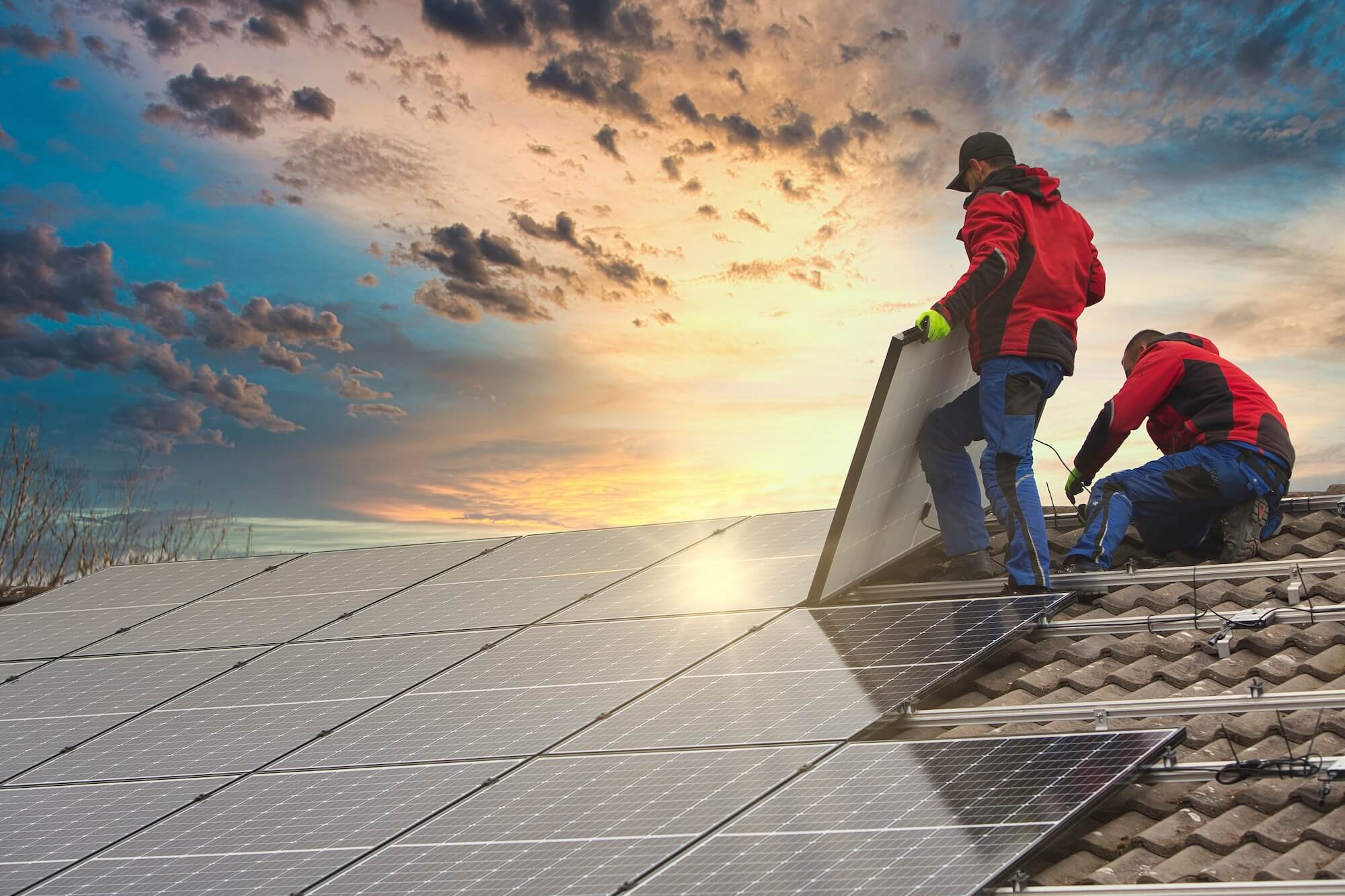 Handwerker installieren PV-Module auf einem Hausdach