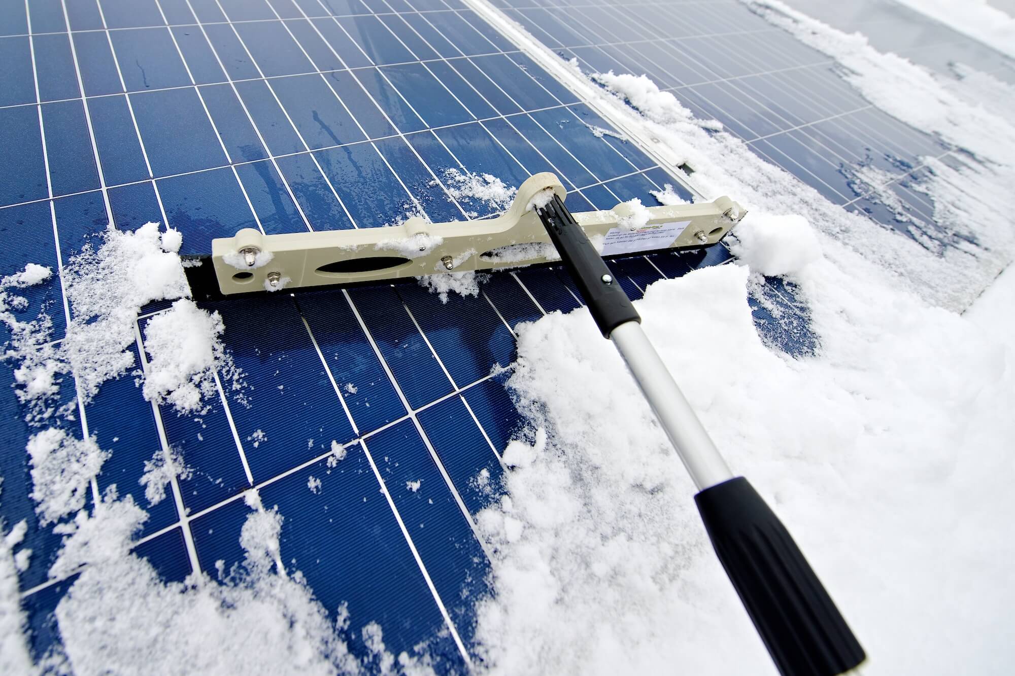 Solarmodul wird mit einem weichen Besen von Schnee befreit.