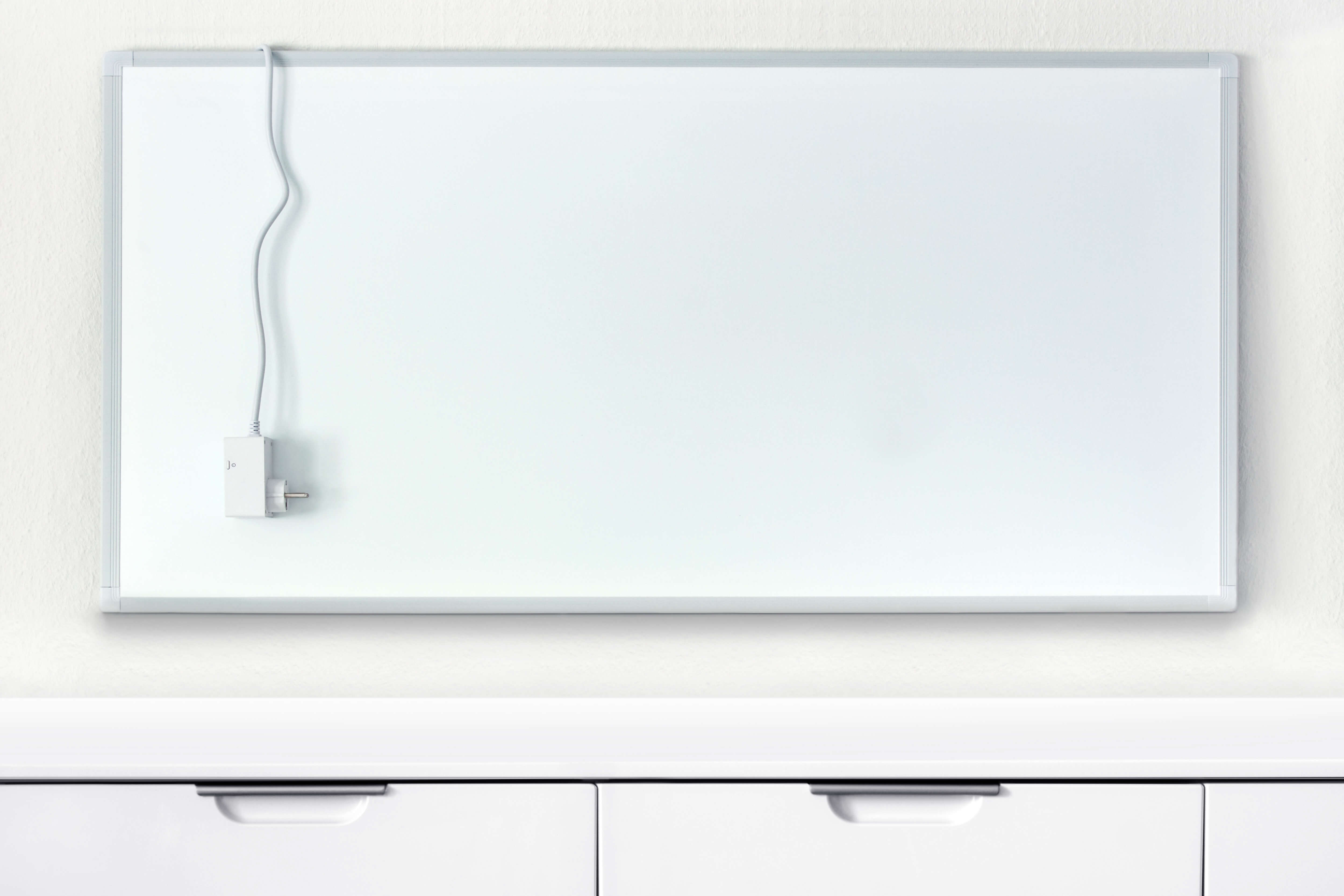 Eine moderne, weiße Infrarotheizung mit Netzkabel als alternatives Heizsystem zur Wärmepumpe