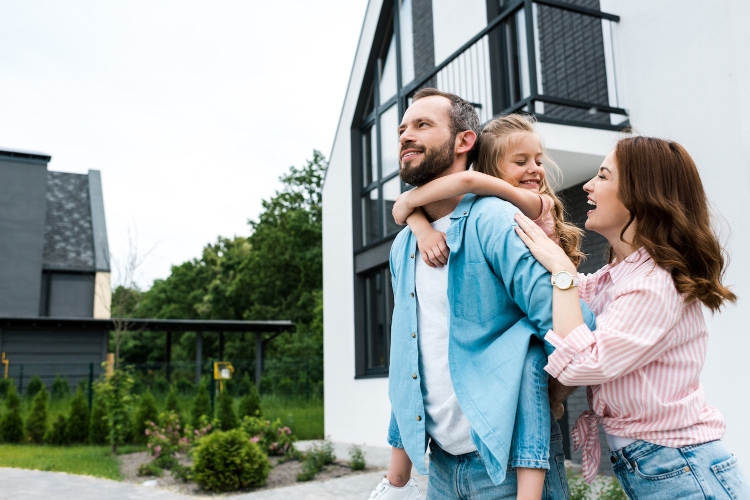 KfW Förderung 2023: Familie vor Einfamilienhaus