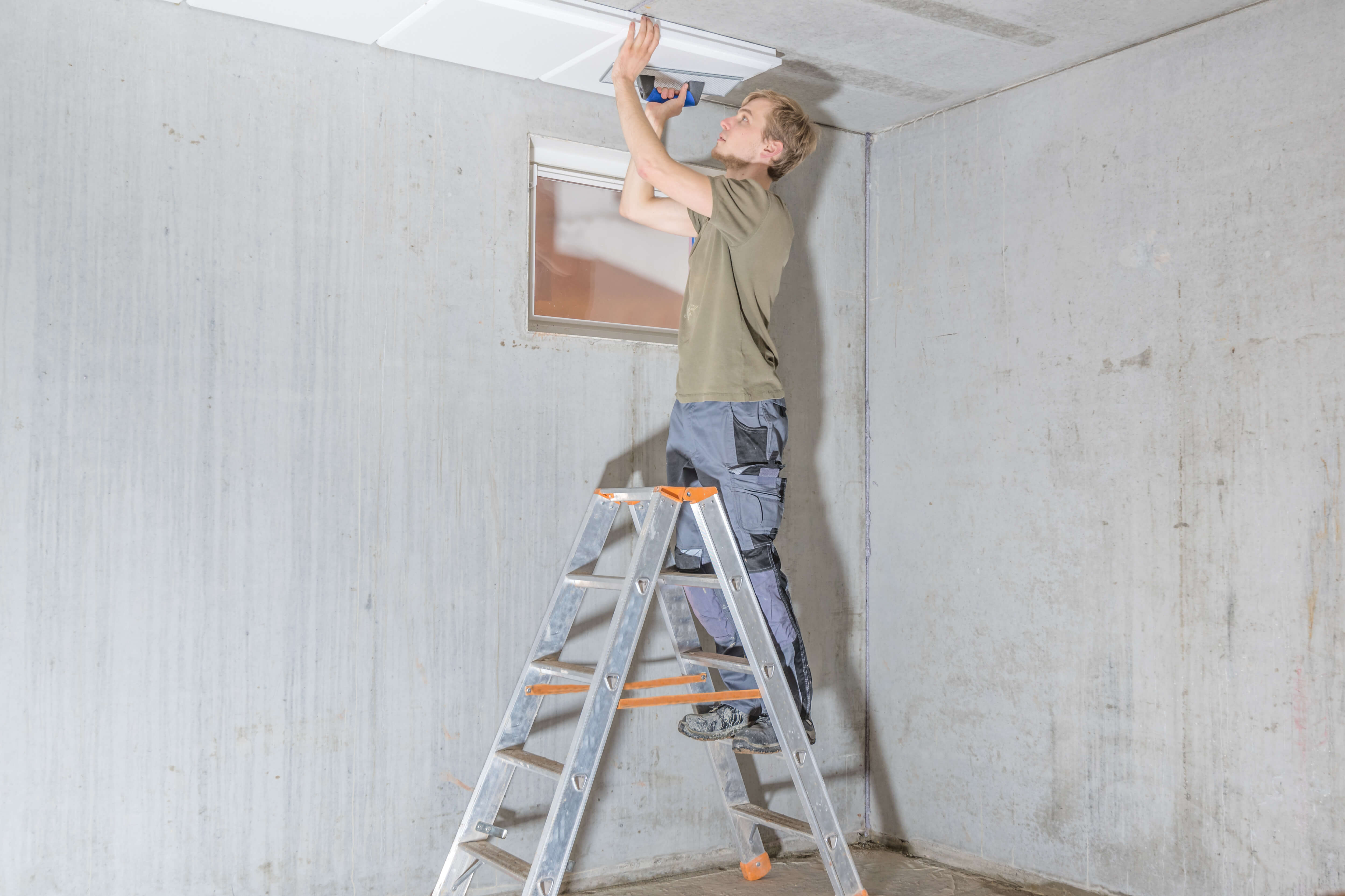 Handwerker dämmt eine Kellerdecke
