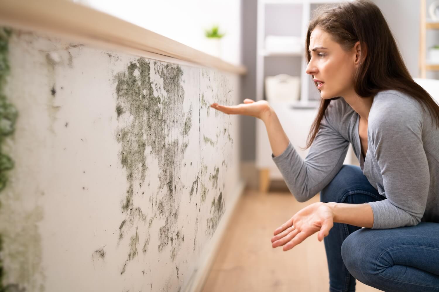 Frau entdeckt Schimmel an der Wand