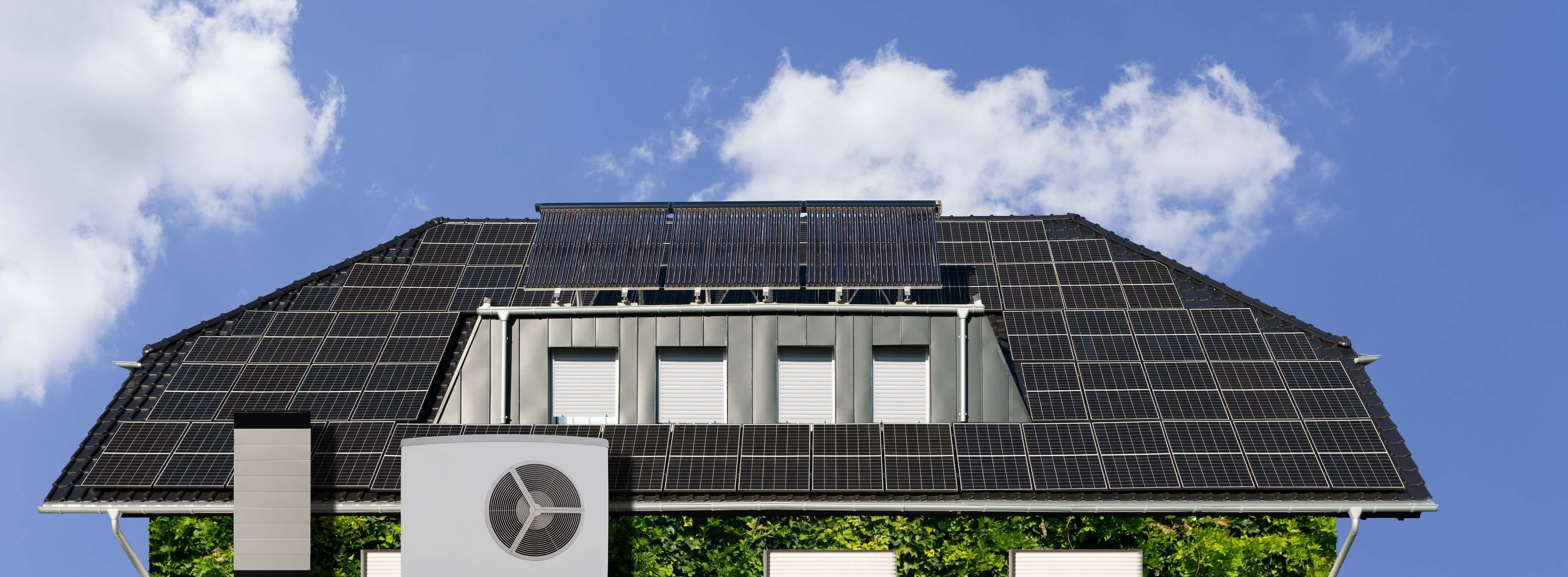 Ein Haus mit auf dem Hausdach installierter Wärmepumpe und Solarthermie in Kombination