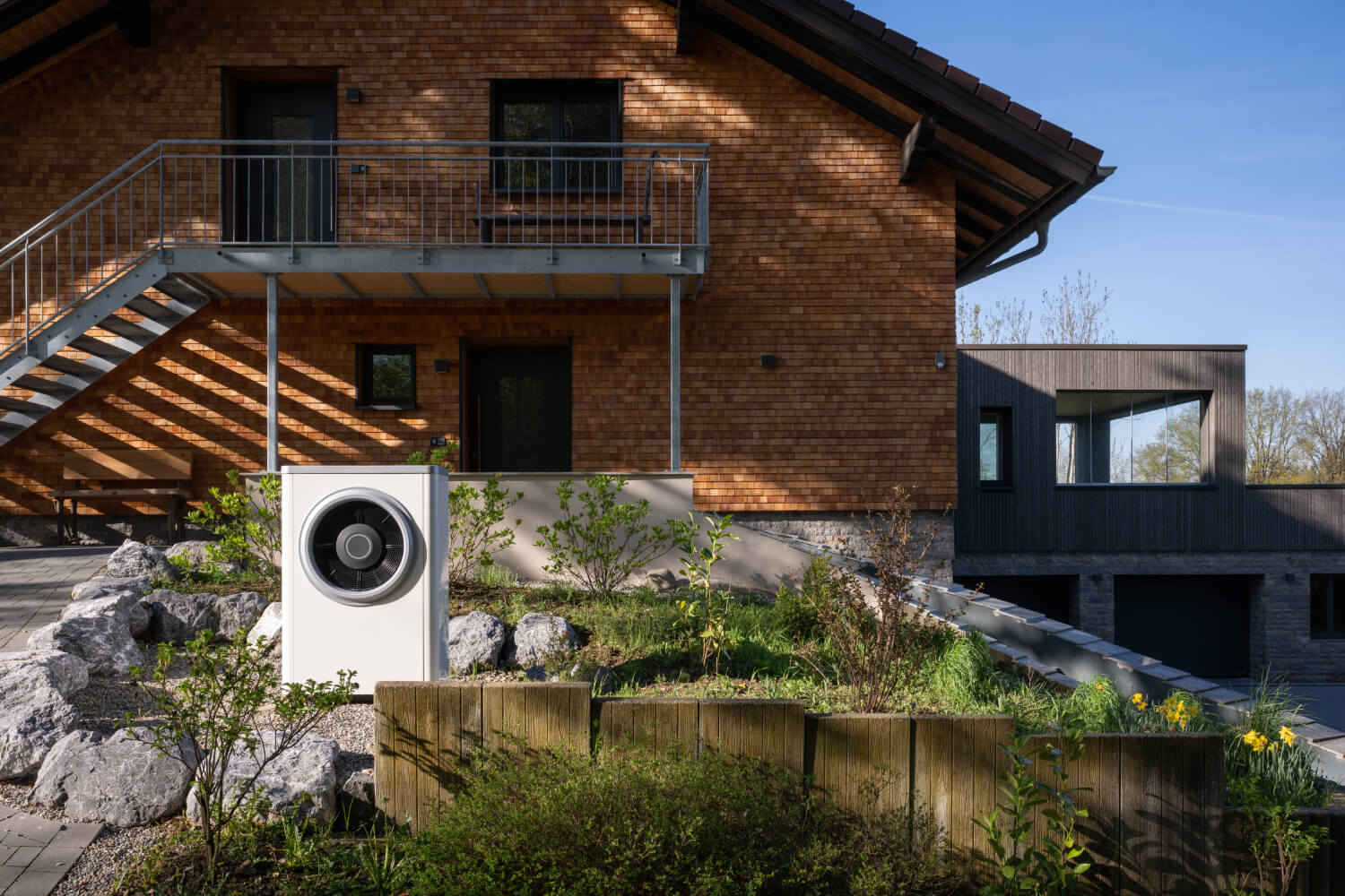 Wärmepumpe von Bosch vor modernem Haus mit Klinker