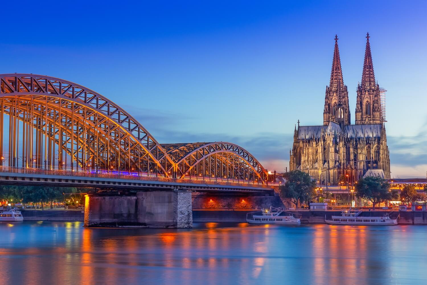 Beleuchtete Brücke über Rhein in Köln, wo Photovoltaik Förderung Solarenergie unterstützt