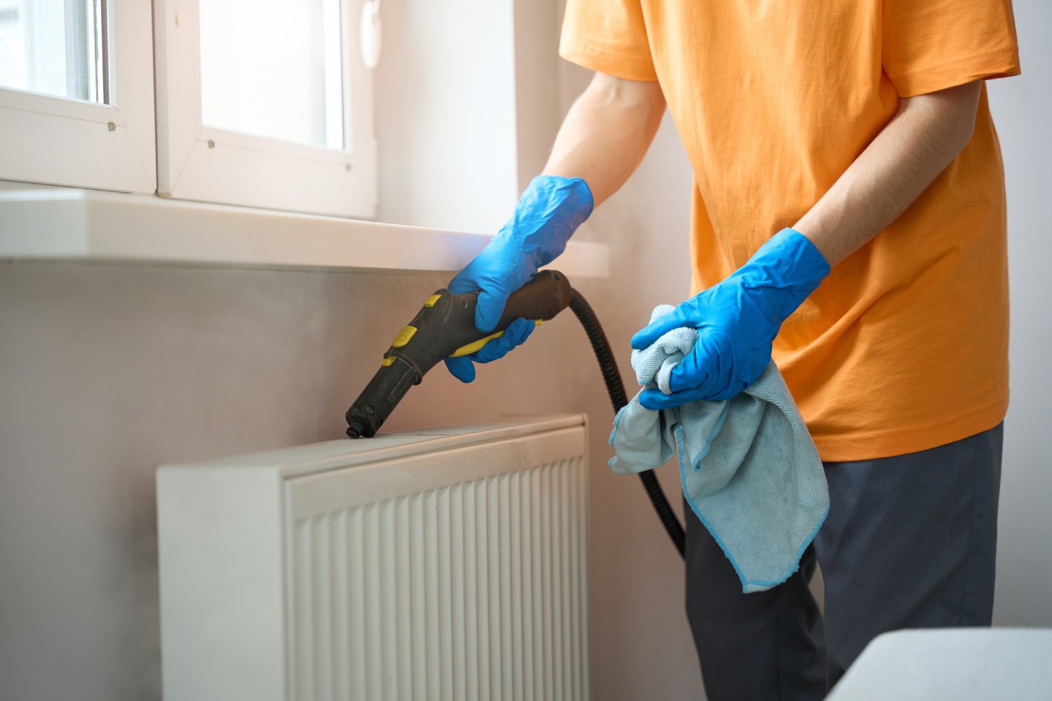 Heizkörper reinigen mit Staubsauger und nassem Lappen