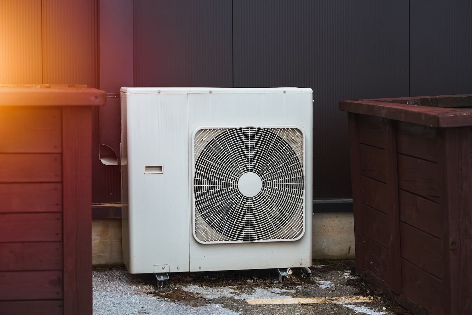 Moderne weiße Wärmepumpe im Einfamilienhaus Außenbereich auf Betonfundament installiert