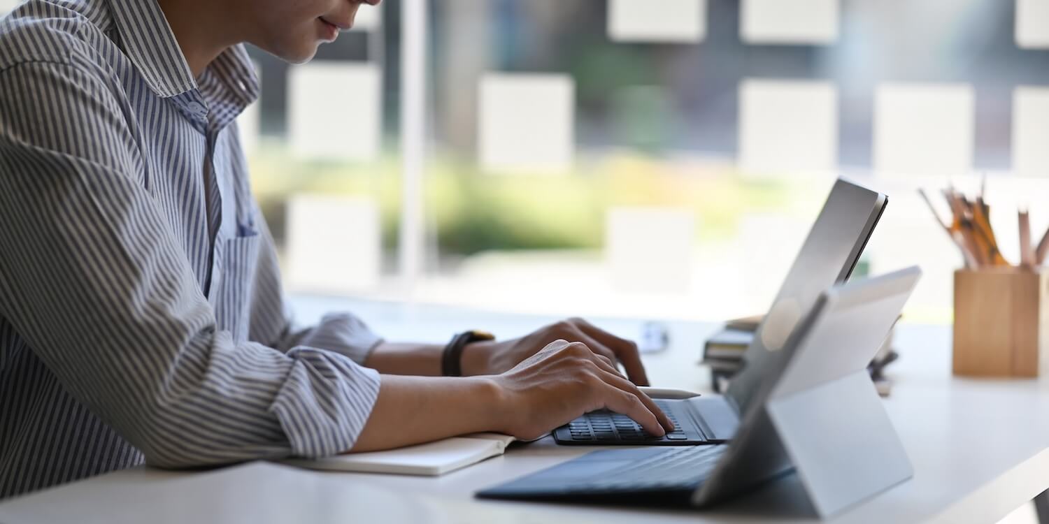 Person arbeitet am Laptop im Büro und recherchiert zur BAFA-Förderung beantragen Anleitung für energetische Modernisierung