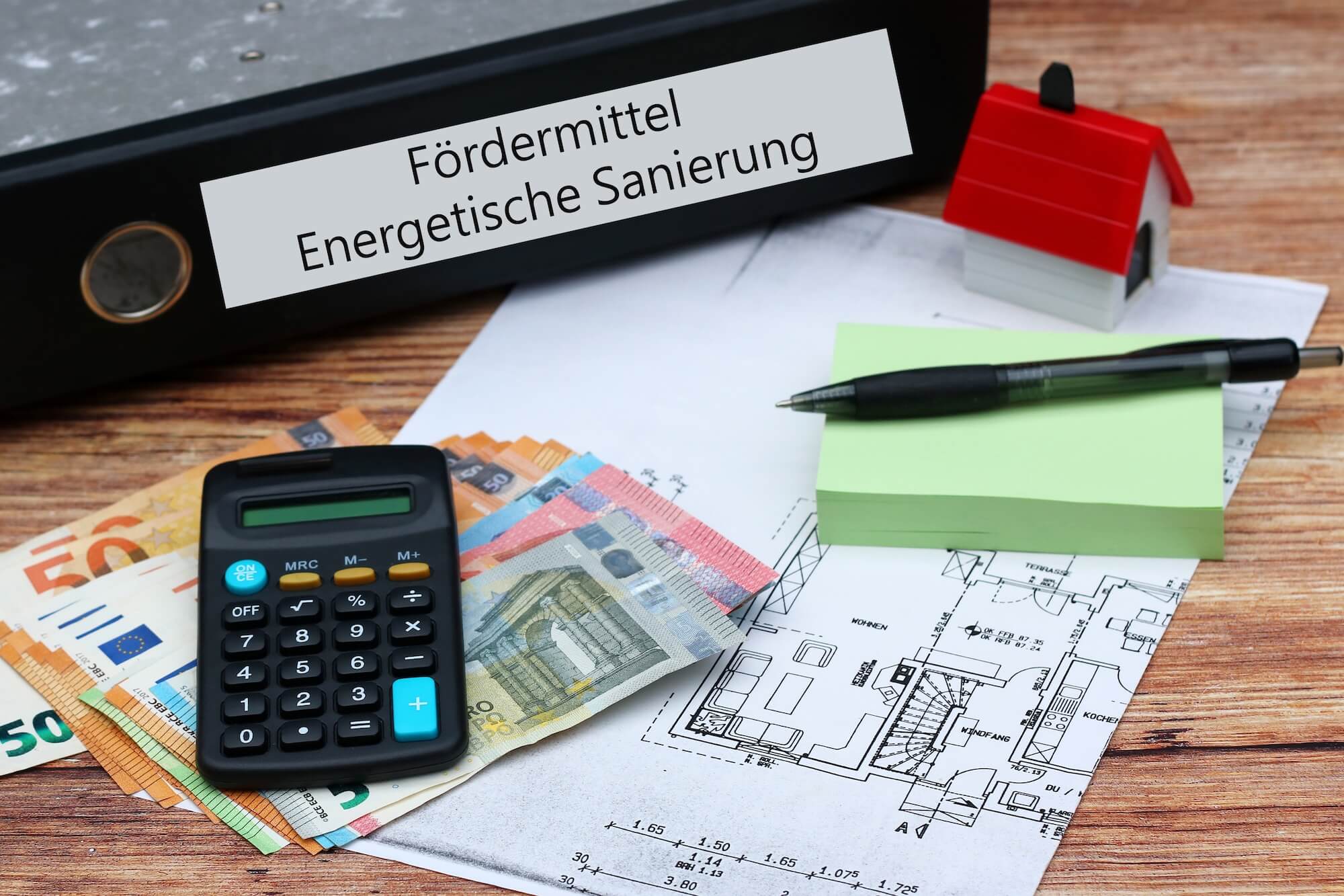 Entscheidungshilfe Sanierung Altbau vs Neubau mit Fördermitteldokumenten und Bauplänen zur Kostenberechnung