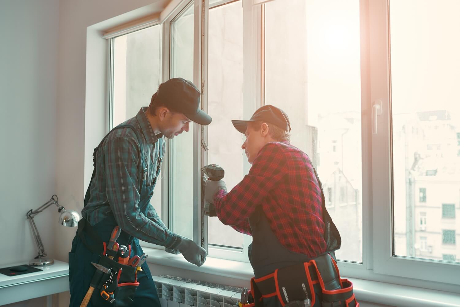 Professionelle Handwerker fĂŒr Fenster bei der Installation eines neuen Fensters im Wohnraum