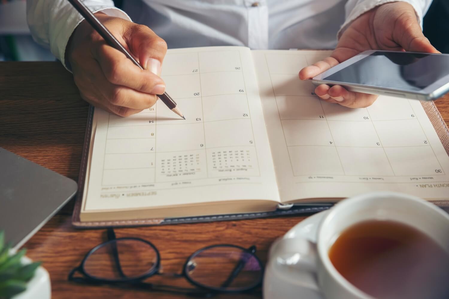 GeschÀftsmann plant Termine im Kalender, um Handwerker Ghosting bei Kunden zu verhindern