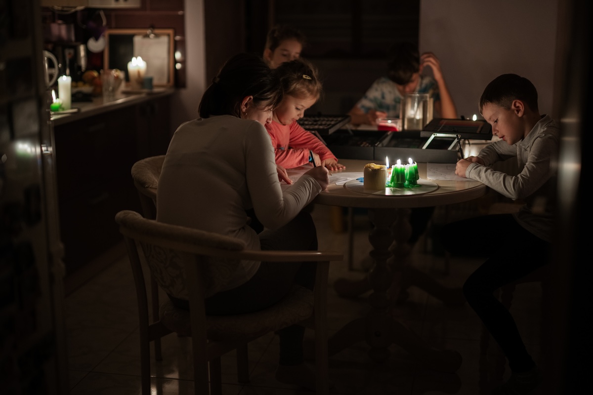 Eine Familie sitz bei Kerzenlicht während eines Blackouts zusammen.
