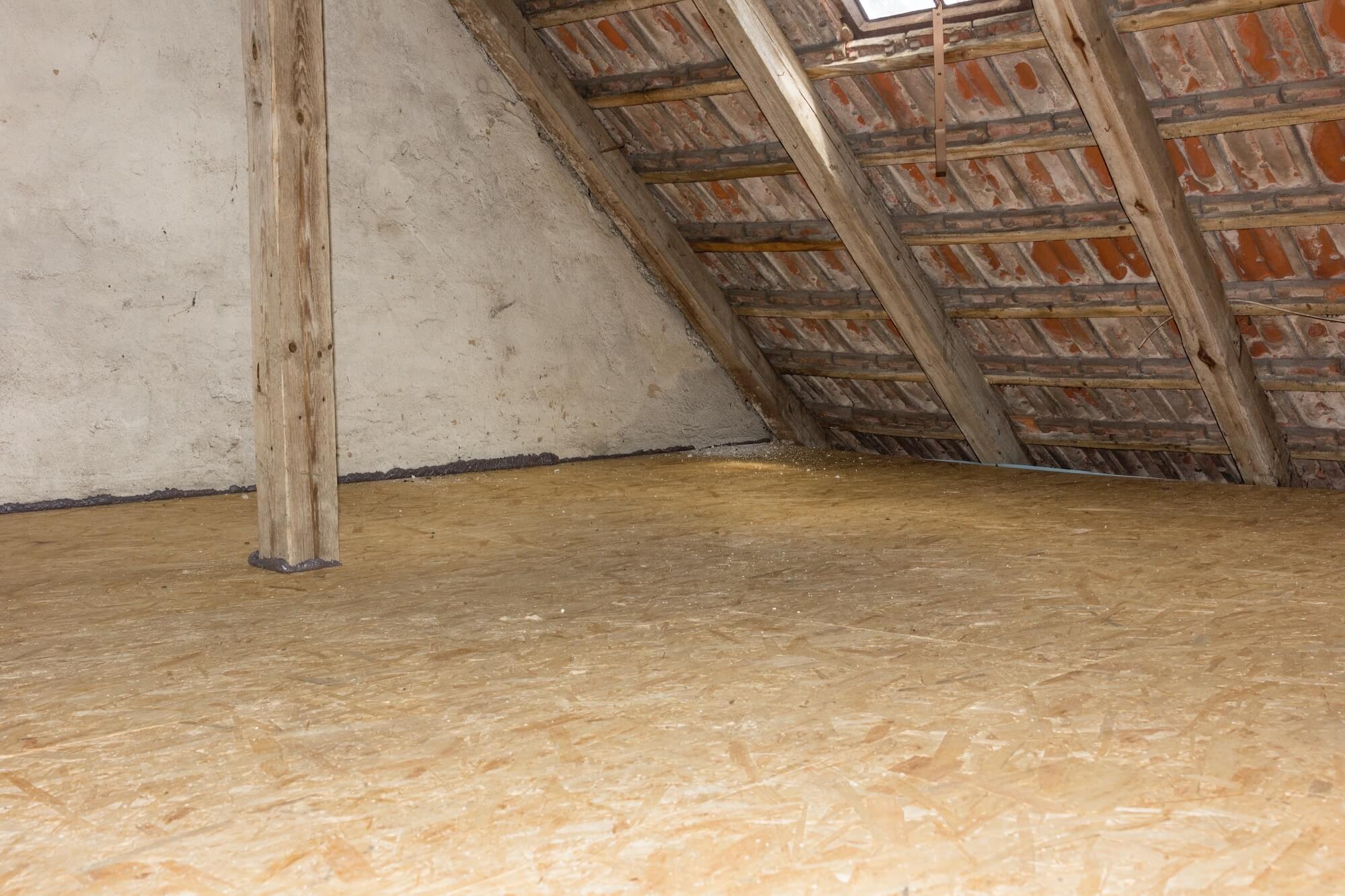 Ein alter Dachboden ohne DĂ€mmung und mit dĂŒnnen Holzbalken