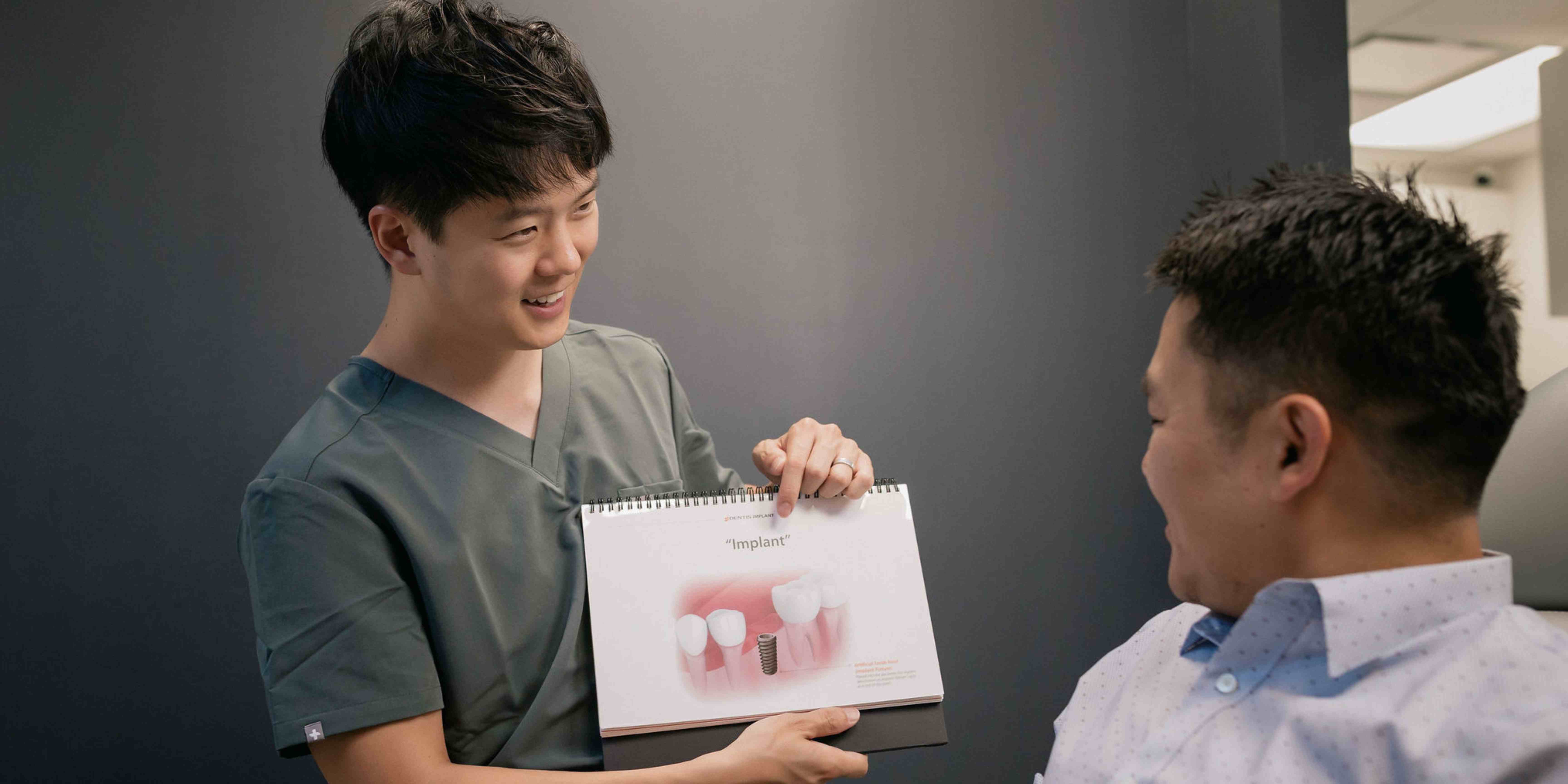 Dr. John Ku with a happy patient after her dental implant 