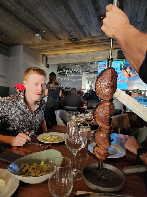 Me looking longingly at a roast on a stick at a Brazilian steakhouse in Toronto.