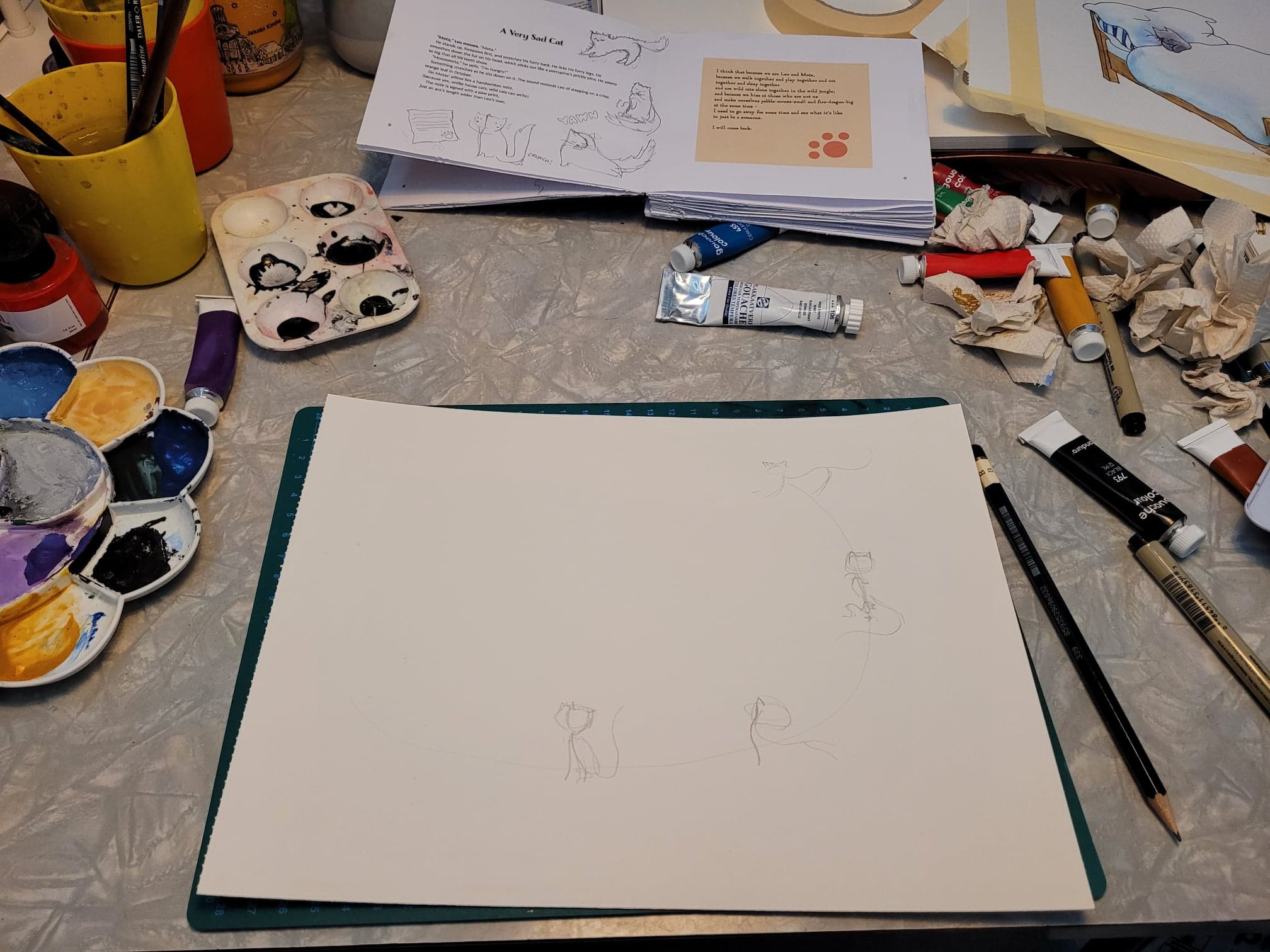A messy workspace, with an in-prgress sketch in the foreground