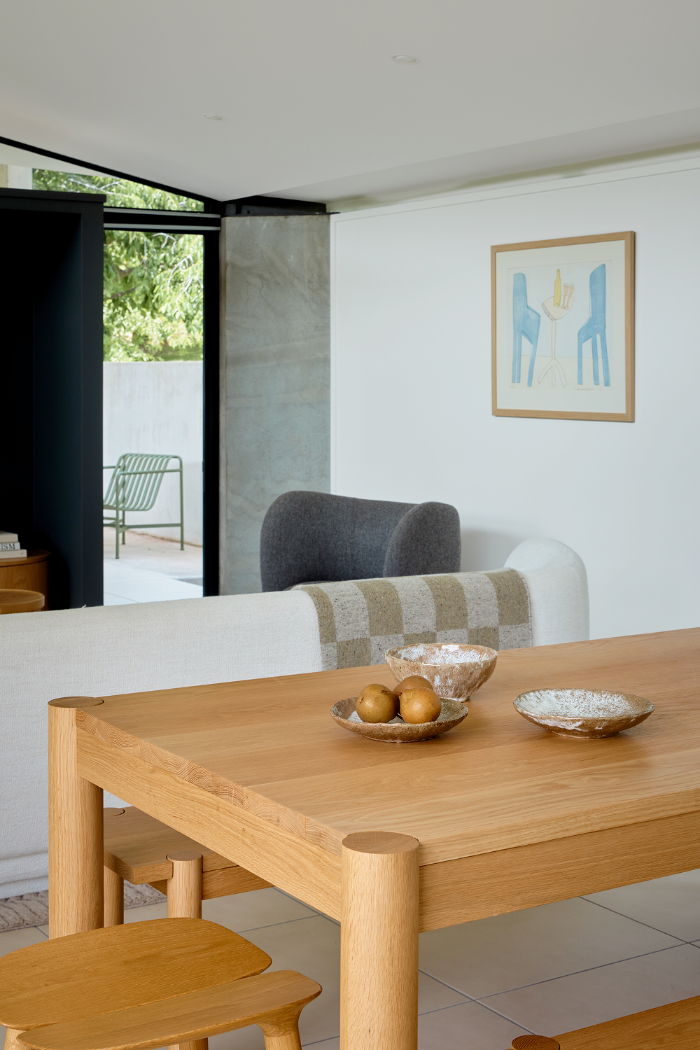 Oak stools and dining table beside white kitchen island and living area