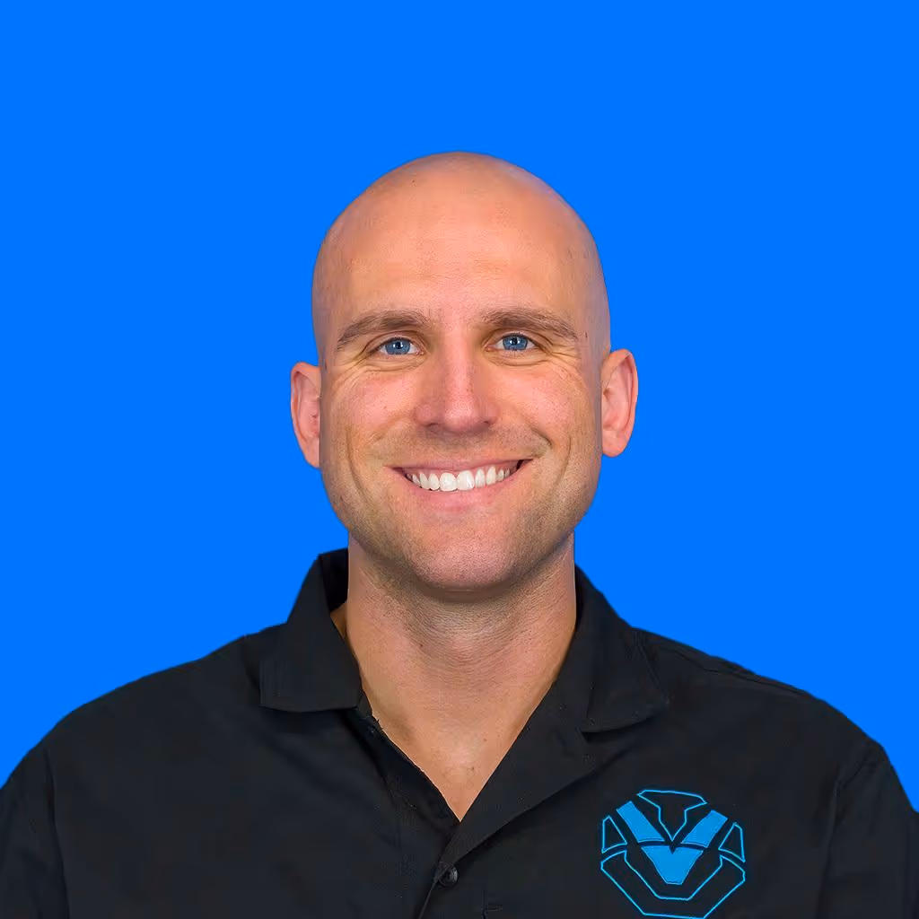 Smiling man with a shaved head.