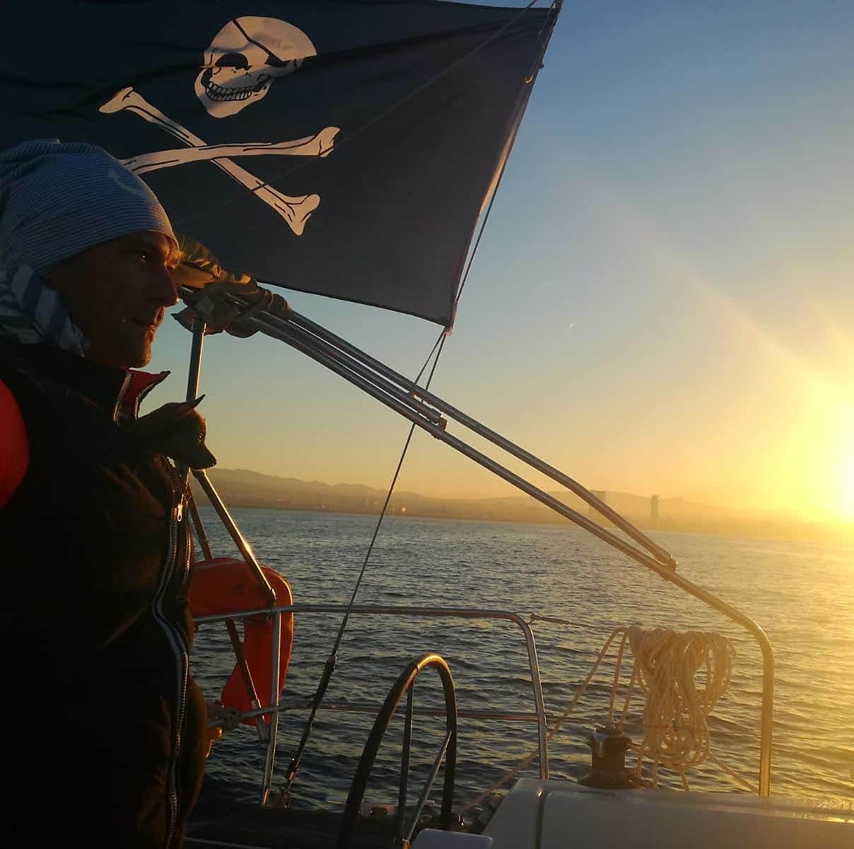 Marek  on board with a dog and pirate flag
