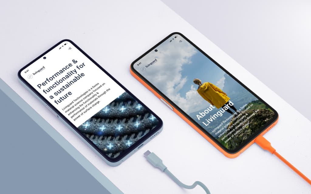 Two smartphones on a white surface displaying Livinguard website pages, one showing performance and functionality text with fabric image, the other showing a person in a yellow jacket outdoors.