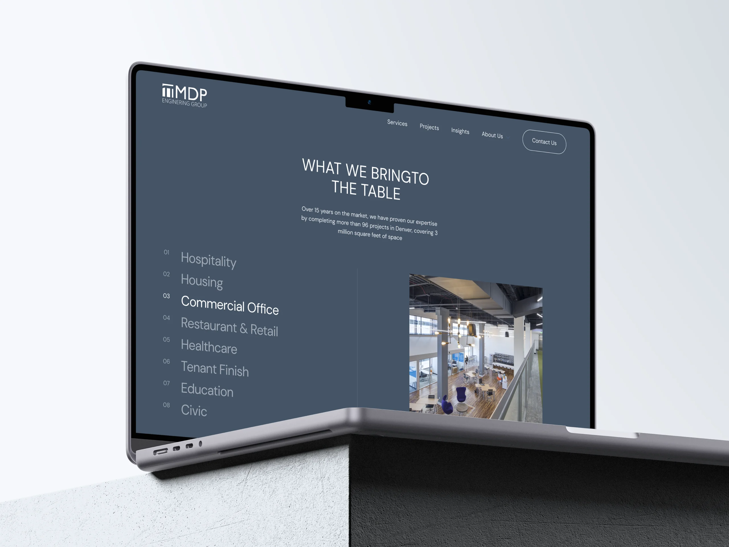 Engineering firm’s website displayed on laptop, highlighting project sectors with a dark blue interface.