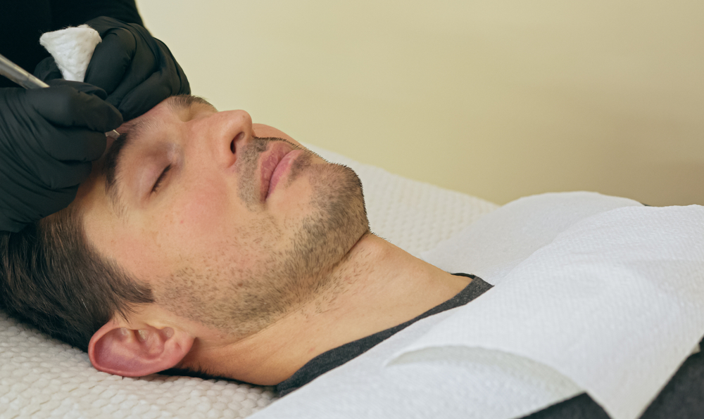 Man receiving professional eyebrow grooming at WaxSpa Miami