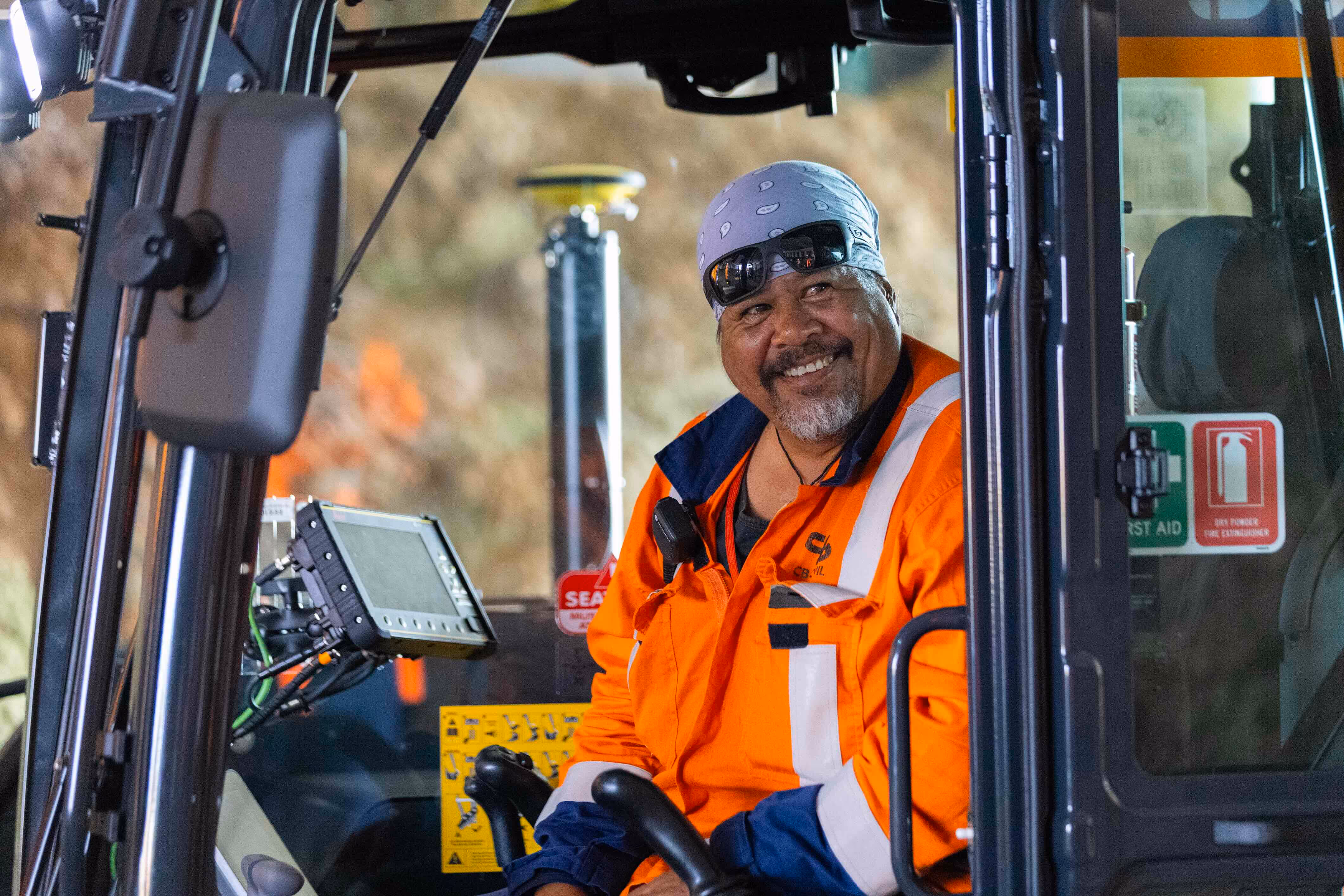 Worker pointing out the window of a digger