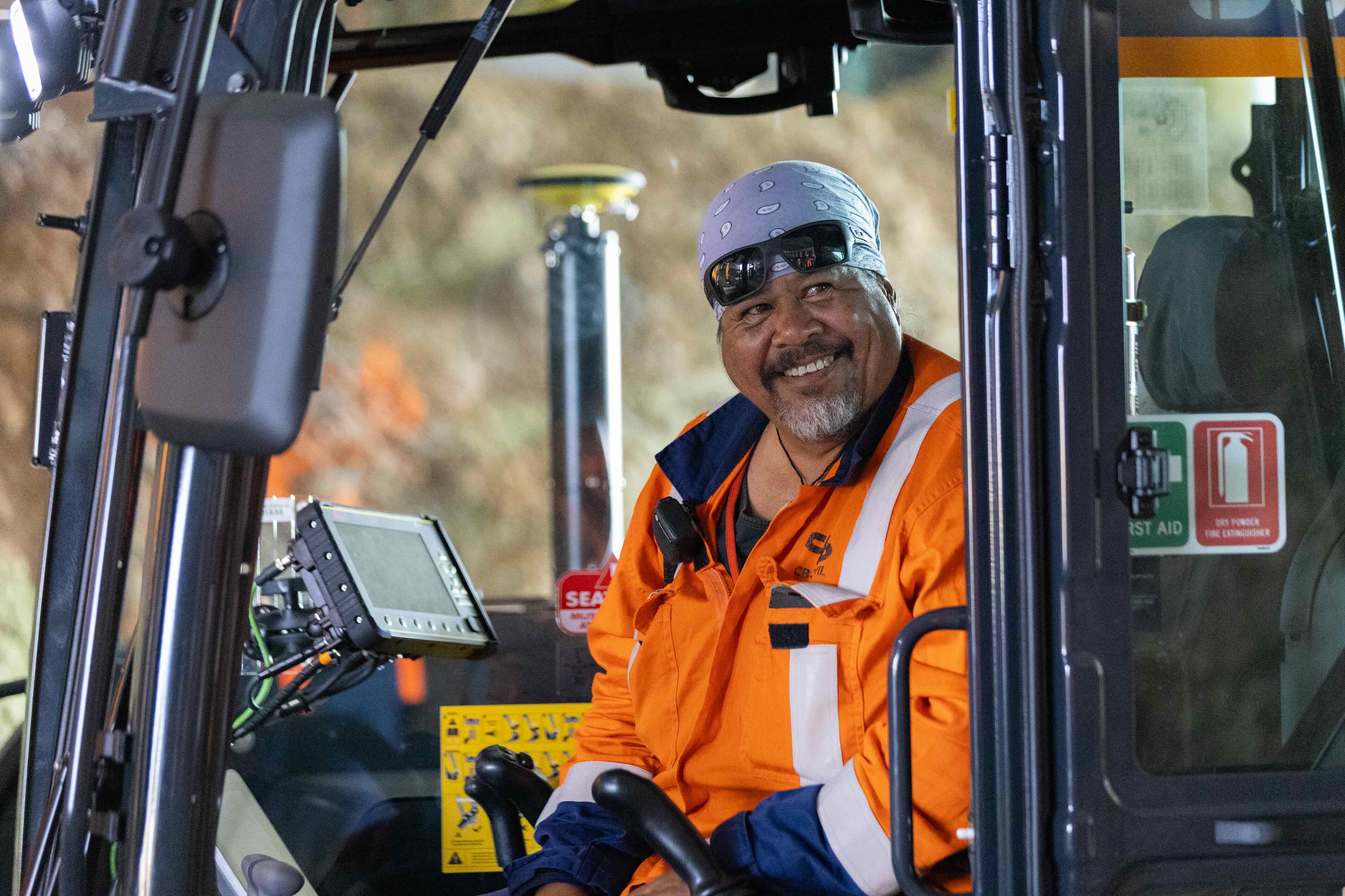 Worker pointing out the window of a digger