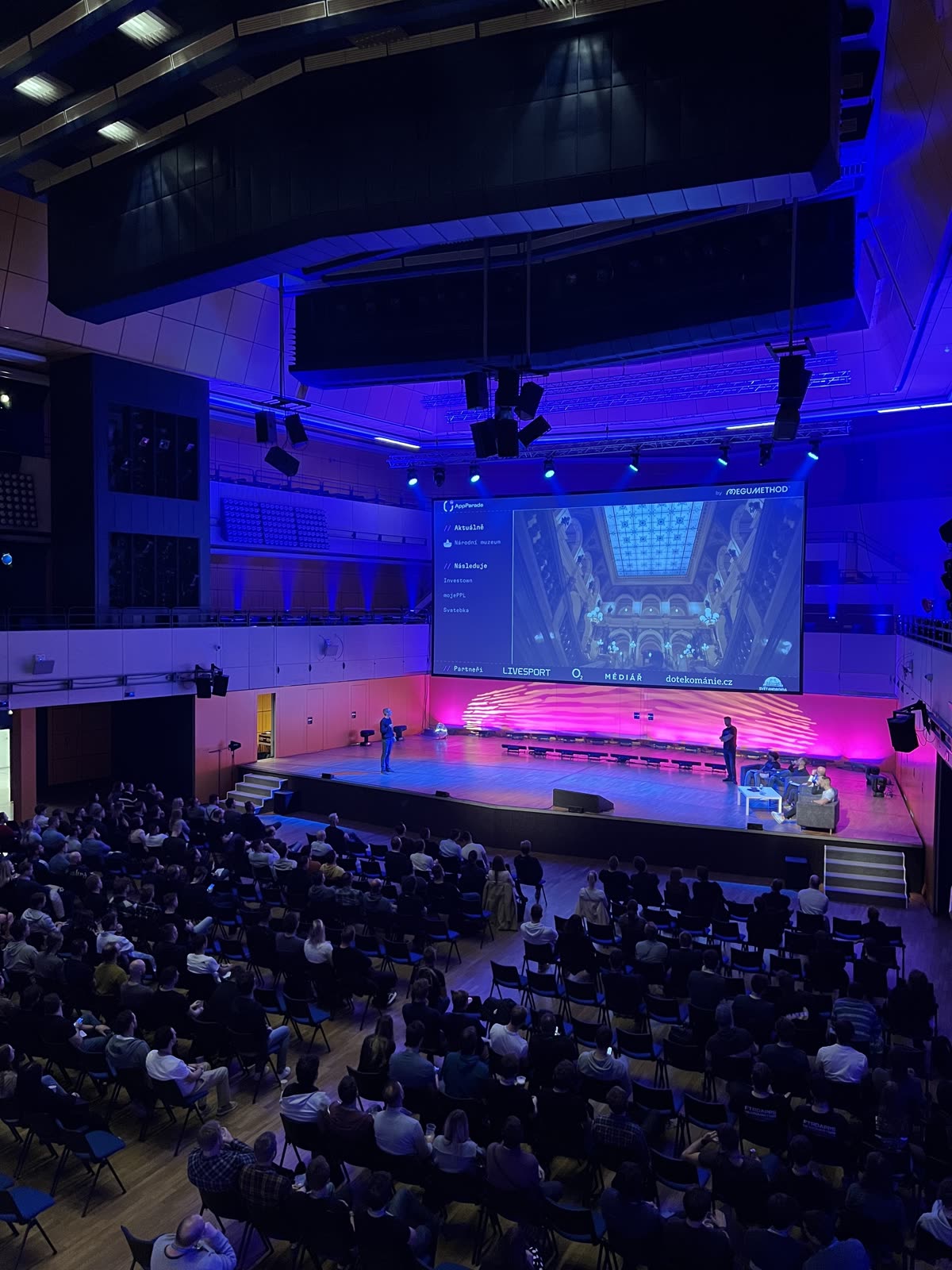 A full hall at AppParade with a lit stage and big screen