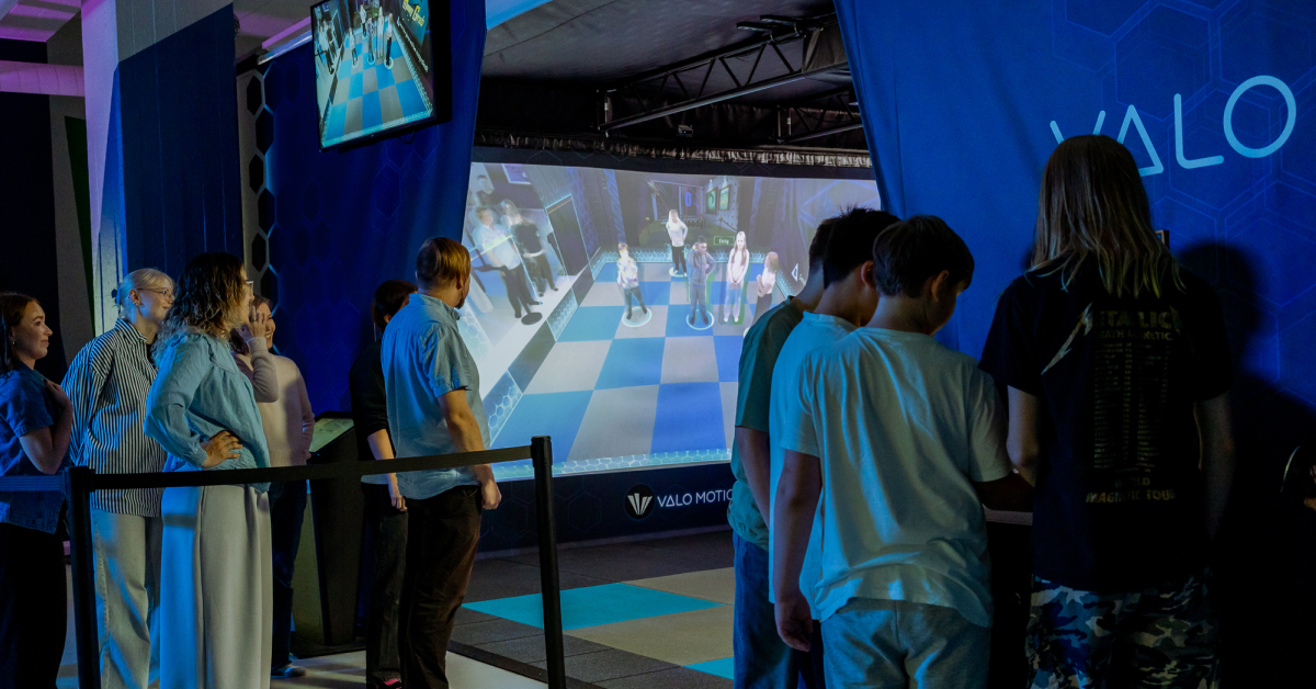 People queuing in front of ValoArena, while 6 players play active mixed-reality games inside 
