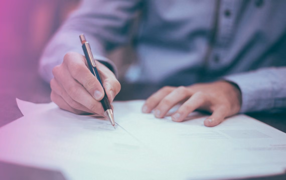 Mann signerer dokumenter