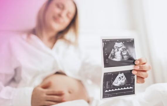 Ung gravid kvinne viser bilde av ultralyd